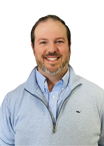 Smiling man wearing a light gray zip-up sweater over a light blue button-down shirt, against a white background.] ,