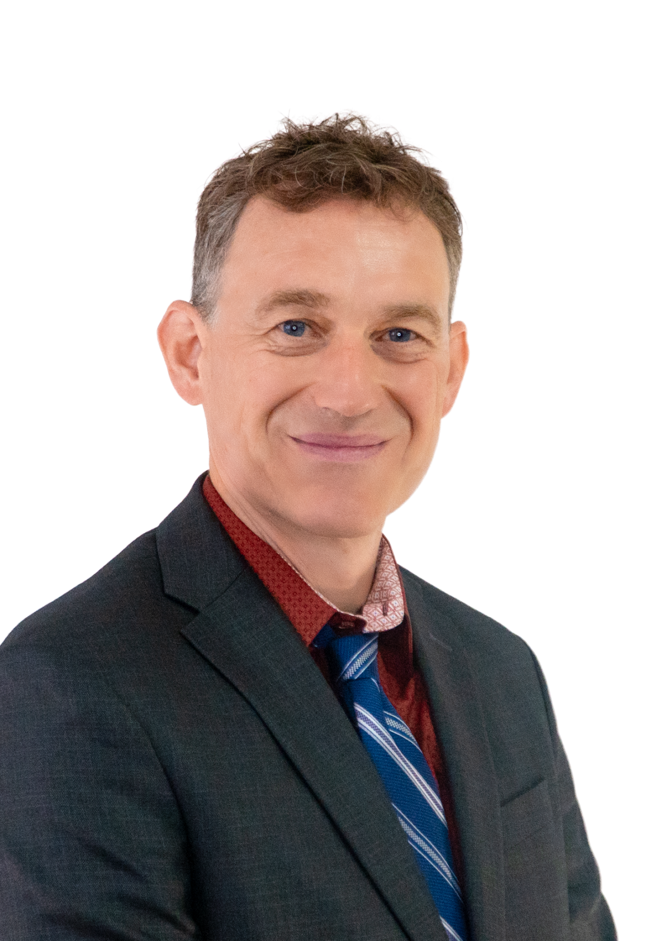 Professional head-and-shoulders portrait of a smiling man in a dark suit and patterned red shirt, blue striped tie